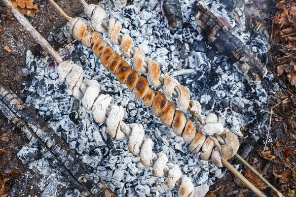 Cooking dough on skewers on a fire — Stock Photo, Image