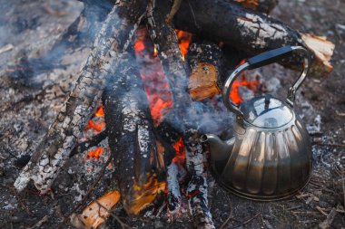 Kettle gölde ateşin yanında duruyor