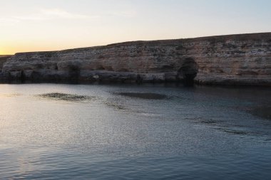 Denizdeki kayalarda gün batımı