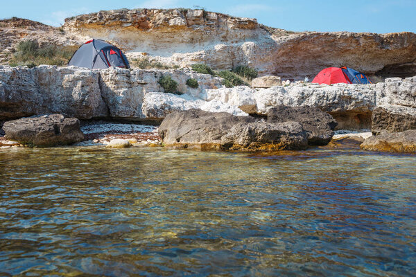 Три палатки на берегу моря. Вид с воды
