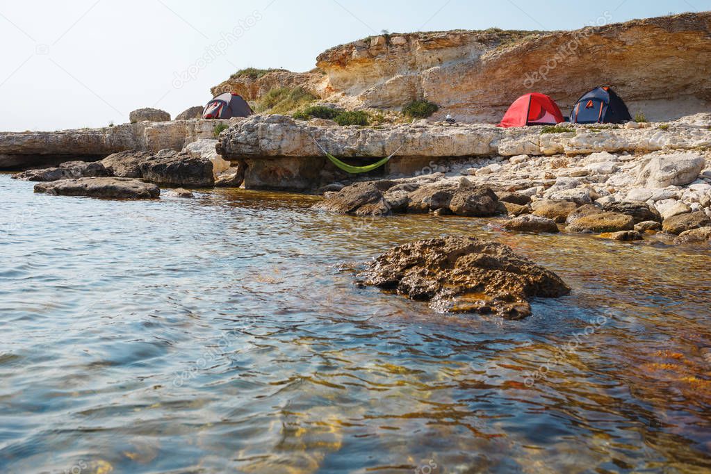 Three tents on the seashore. View from the water