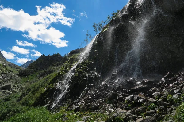 Mountain waterfall in sunny day. Altai mountains, Siberia, Russia