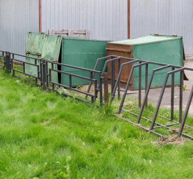 Yeşil çim yanındaki hurda bahçesinde yalan eski paslı Çöp Konteyneri