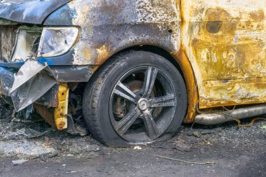 Front wheel and headlight of burnt car. Damage as result of spontaneous combustion or arson. Insurance event clipart
