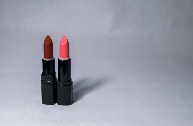 Pembe ve kırmızı iki ruj bir kap üzerinde sol tarafında beyaz bir arka plan olmadan dik duruyorum