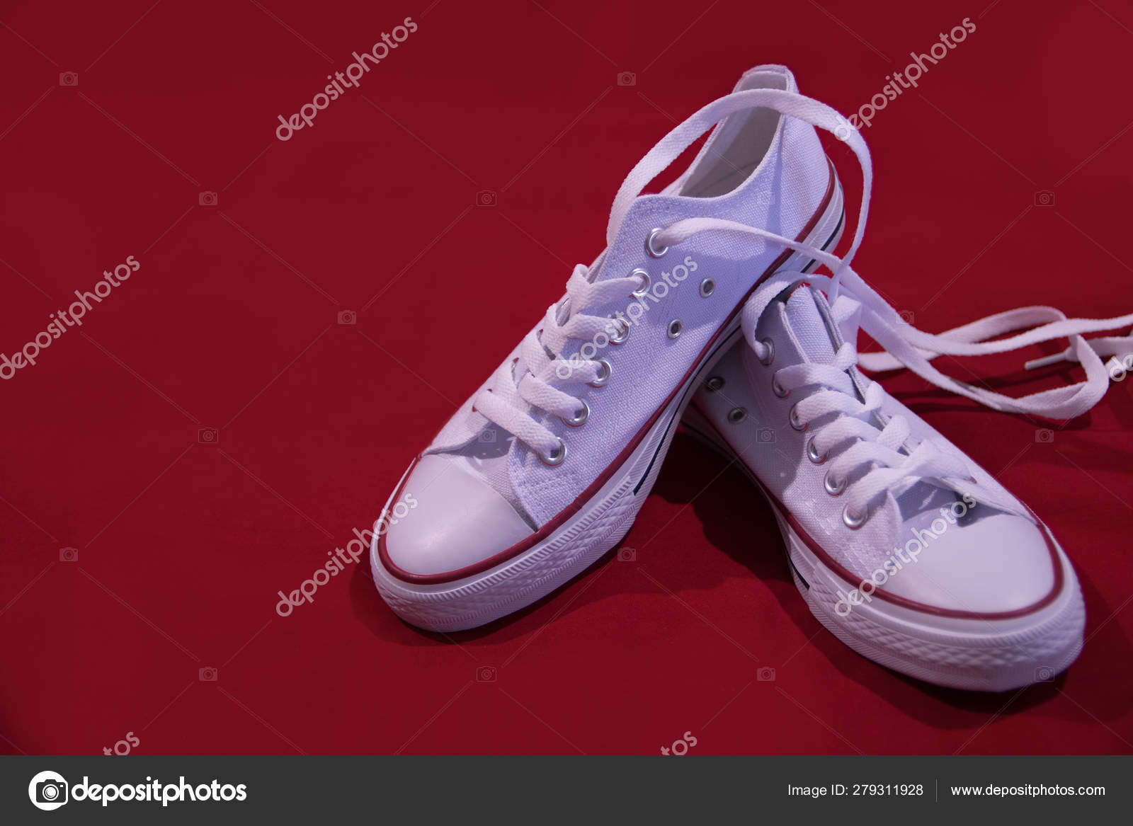 White keds with laces on a red 
