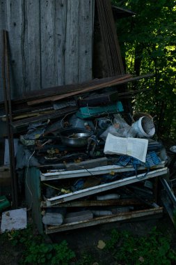 Çöplükte yatan küçük bir çöp yığını, terk edilmiş bir kitap, gereksiz bir eski tava.