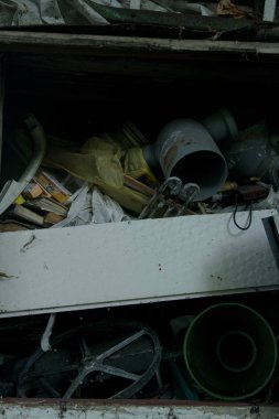 Plastikten yapılmış çöp yığını, araba sürücüsü, borular ve kaçak çöplüğe atılan tenekeler
