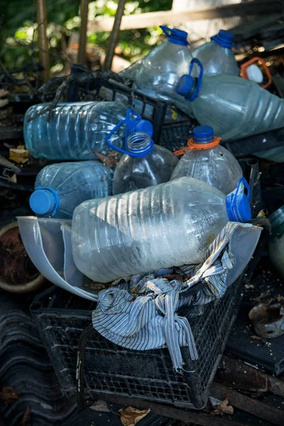 Pile of plastic bottles and rubbish lying on illegal dump in the forest