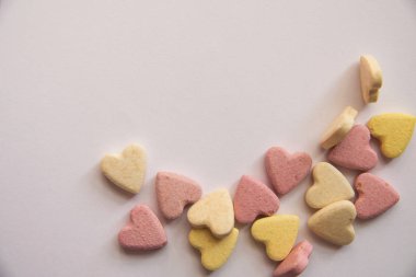 pembe ve sarı Vitaminler bir kalp şeklinde boş bir nokta bırakarak sayfanın bir tarafında eşit sırada beyaz bir arka plan üzerinde yalan