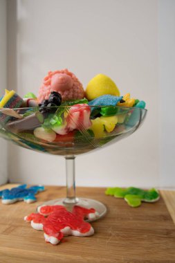 Çok renkli marmelat şekerlemeleri cam şeker tutacağında, büyük pembe bir koyunda yatıyor.