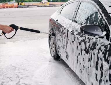 Köpük tabancasıyla lavaboda yıkanmış gri bir araba.