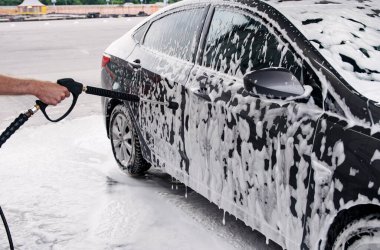 Köpük tabancasıyla lavaboda yıkanmış gri bir araba.