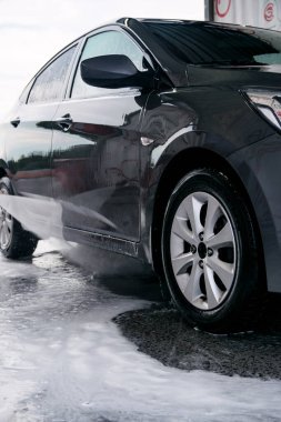 Deterjan lavabodaki gri arabanın yan tarafından suyla yıkanmış.