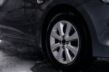 Deterjan lavabodaki gri arabanın yan tarafından suyla yıkanmış.