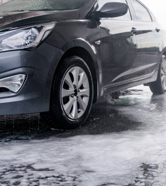 Deterjan lavabodaki gri arabanın yan tarafından suyla yıkanmış.