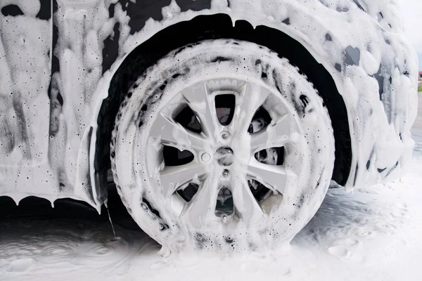 Lavabodaki deterjan köpüğünde gri bir arabanın tekerleği.