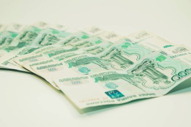 Beyaz arka planda 1000 ruble nakit para yatıyor.