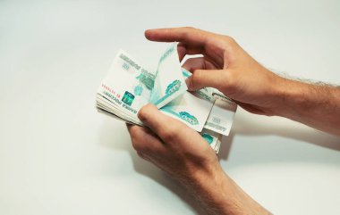 Eldeki adam Rus kağıt para notlarını sayar.