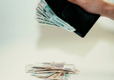 Adam siyah bir cüzdandan kağıt para çıkarıyor.