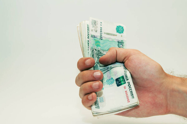 мужская рука держит банкноты на наличные в тысячу рублей
