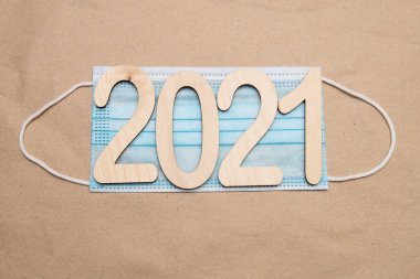 2021 numaralı hafif ahşap kutu, el işi kağıt üzerinde tek kullanımlık tıbbi bir maskenin üzerinde yatıyor.
