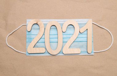 2021 numaralı hafif ahşap kutu, el işi kağıt üzerinde tek kullanımlık tıbbi bir maskenin üzerinde yatıyor.