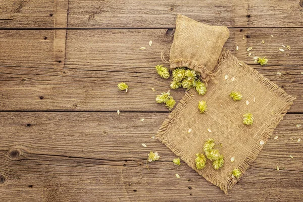 Ganze Hopfen in Tüten auf einem alten Holztisch. Brauerei. Bierzutaten. Sack Hopfen auf alten Brettern Hintergrund — Stockfoto