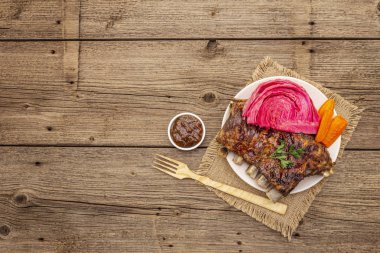 Mayalanmış lahana, fırında havuç, taze maydanoz ve domuz pirzolası.