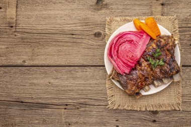 Mayalanmış lahana, fırında havuç, taze maydanoz ve domuz pirzolası.