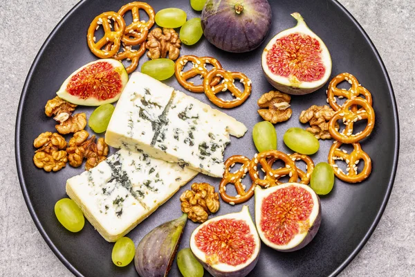 Сырная тарелка с голубым сыром, орехами, инжиром, виноградом, крендельками — стоковое фото
