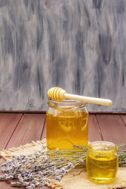 Cam kavanozlarda taze sıvı bal ve ahşap bal kaplaması.