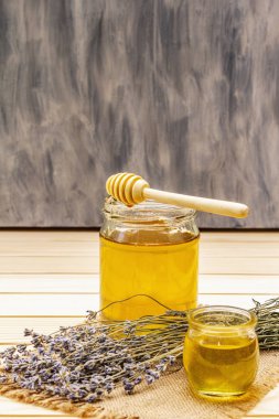 Cam kavanozlarda taze sıvı bal ve ahşap bal kaplaması.