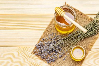 Cam kavanozlarda taze sıvı bal ve ahşap bal kaplaması.