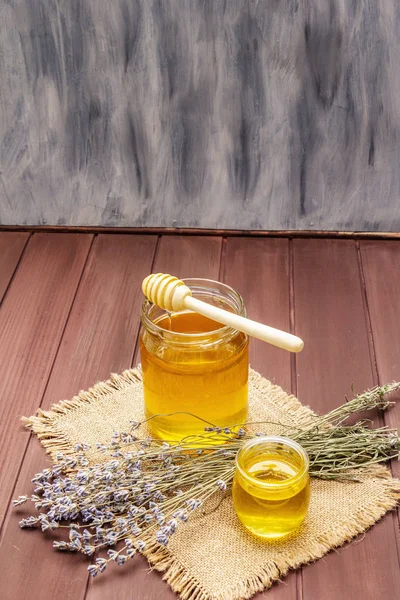 Mel líquido fresco em jarros de vidro com um conta-gotas de mel de madeira — Fotografia de Stock