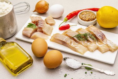 Çiğ morina filetosu sebze, baharat, yumurta, zeytinyağı ve un.