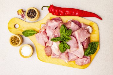 Çiğ domuz boynu, taze sebzeler ve kuru baharatla parçalara ayrılmış.