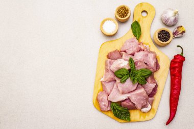 Çiğ domuz boynu, taze sebzeler ve kuru baharatla parçalara ayrılmış.