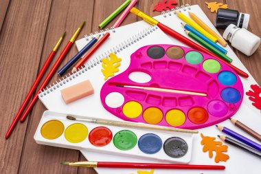 Okul konseptine geri dönelim. Kahverengi tahta arka planda okul eğitimi malzemeleri