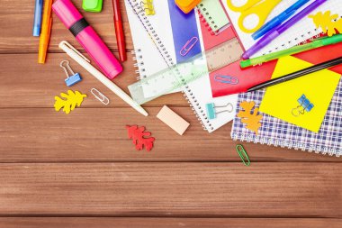 Okul konseptine geri dönelim. Kahverengi tahta arka planda okul eğitimi malzemeleri