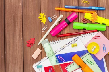 Okul konseptine geri dönelim. Kahverengi tahta arka planda okul eğitimi malzemeleri