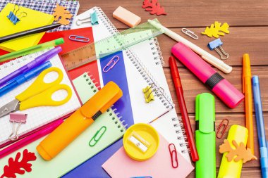 Okul konseptine geri dönelim. Kahverengi tahta arka planda okul eğitimi malzemeleri