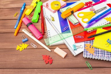 Okul konseptine geri dönelim. Kahverengi tahta arka planda okul eğitimi malzemeleri