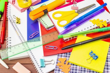 Okul konseptine geri dönelim. Kahverengi tahta arka planda okul eğitimi malzemeleri