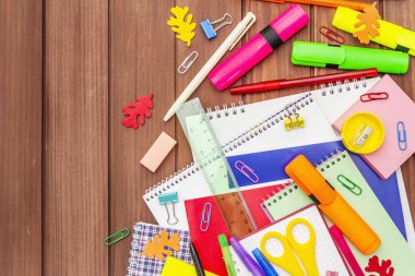 Okul konseptine geri dönelim. Kahverengi tahta arka planda okul eğitimi malzemeleri