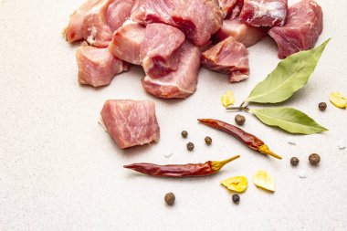 Çiğ domuz omzu, baharatlı parçalara ayrılmış.