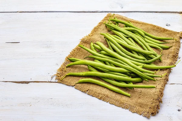 Phaseolus vulgaris, fasole verde comună sau fasole de rinichi pe sac rustic — Fotografie, imagine de stoc