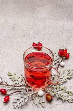 Sosisli gül çayı. Taze böğürtlenli, yapraklı ve şekerli iyi bir ruh hali için kış içkisi. Taş beton arka plan