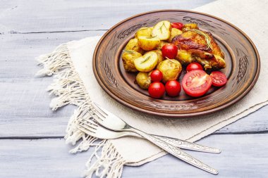 Kızarmış tavuk butları ve bebek patatesler.