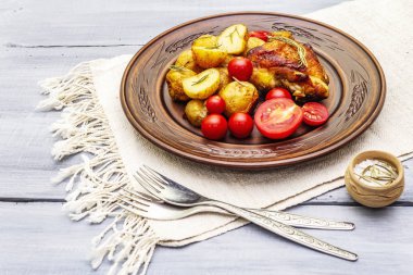 Kızarmış tavuk butları ve bebek patatesler.